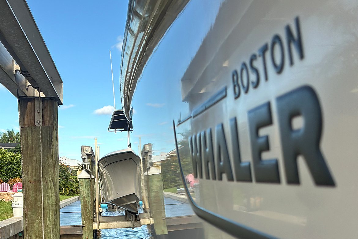 Boston Whaler hull so glossy it mirrors the dock and lift